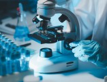 Biochemical,Research,Scientist,Working,With,Microscope,For,Coronavirus,Vaccine,Development